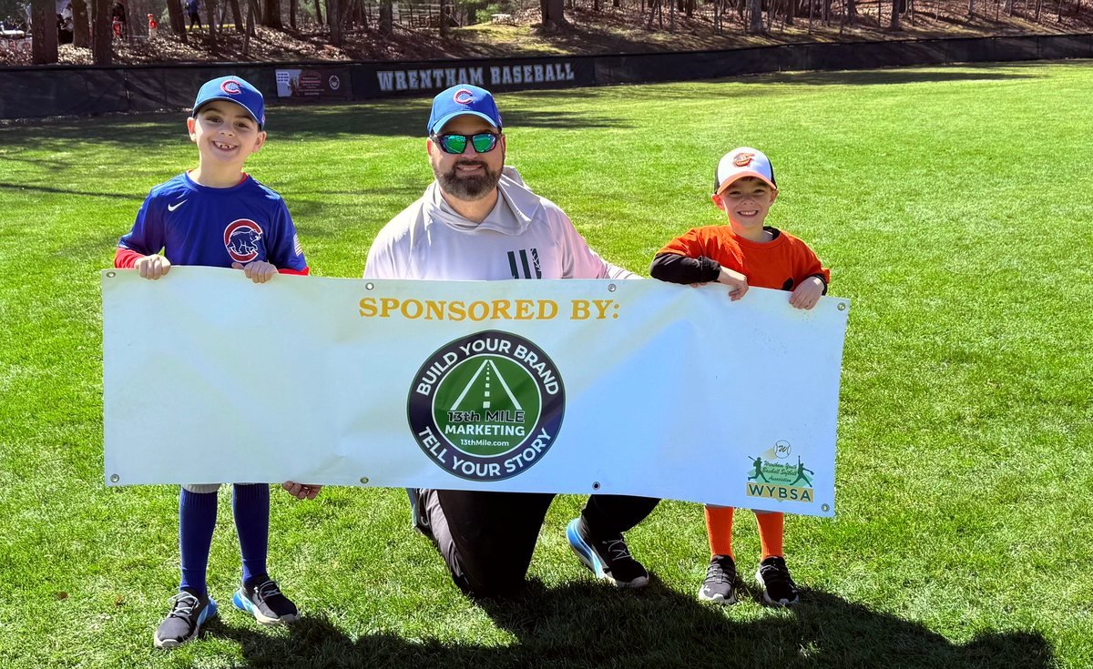 BJ Corey kneeling with his two kids on a Wrentham baseball field